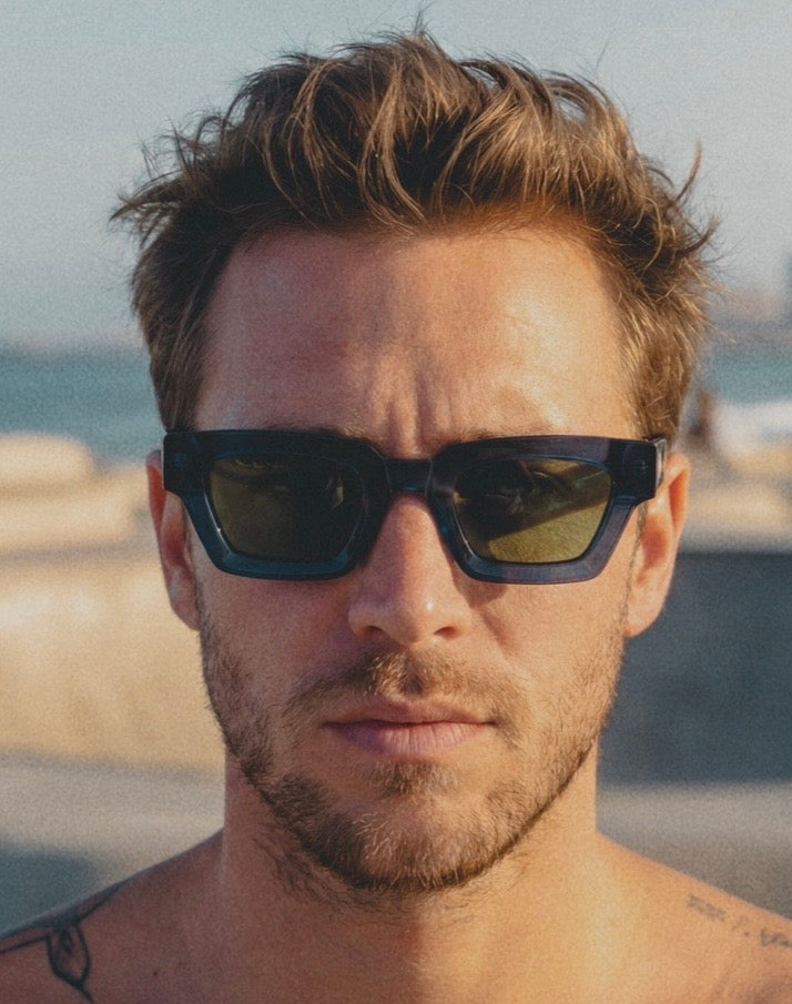 Man wearing sunglasses with a blurred beach background